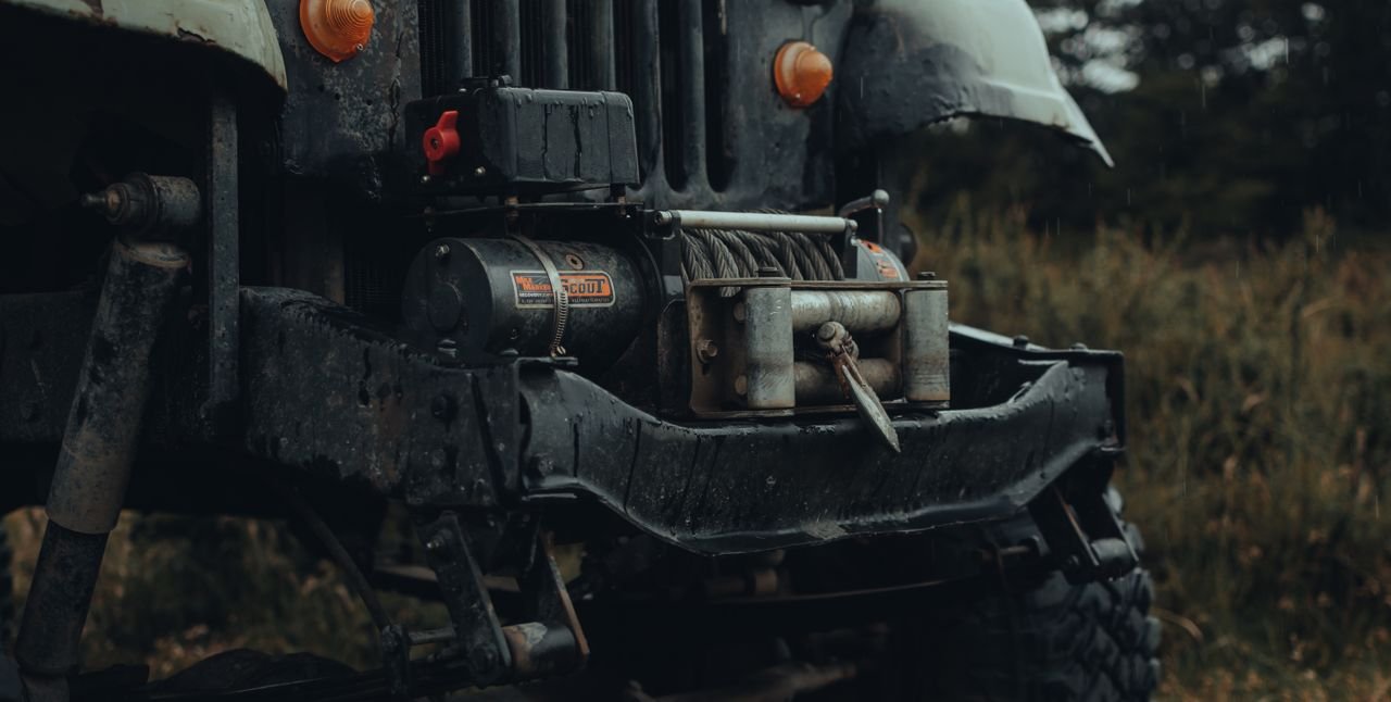 Detailed view of an off-road vehicle bumper with a metal tow winch, ready for adventure.