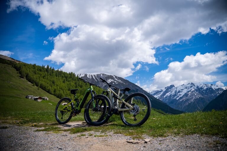Parked mountain bikes under a blue sky with the snowcapped Alps in Livigno, perfect for summer adventures.